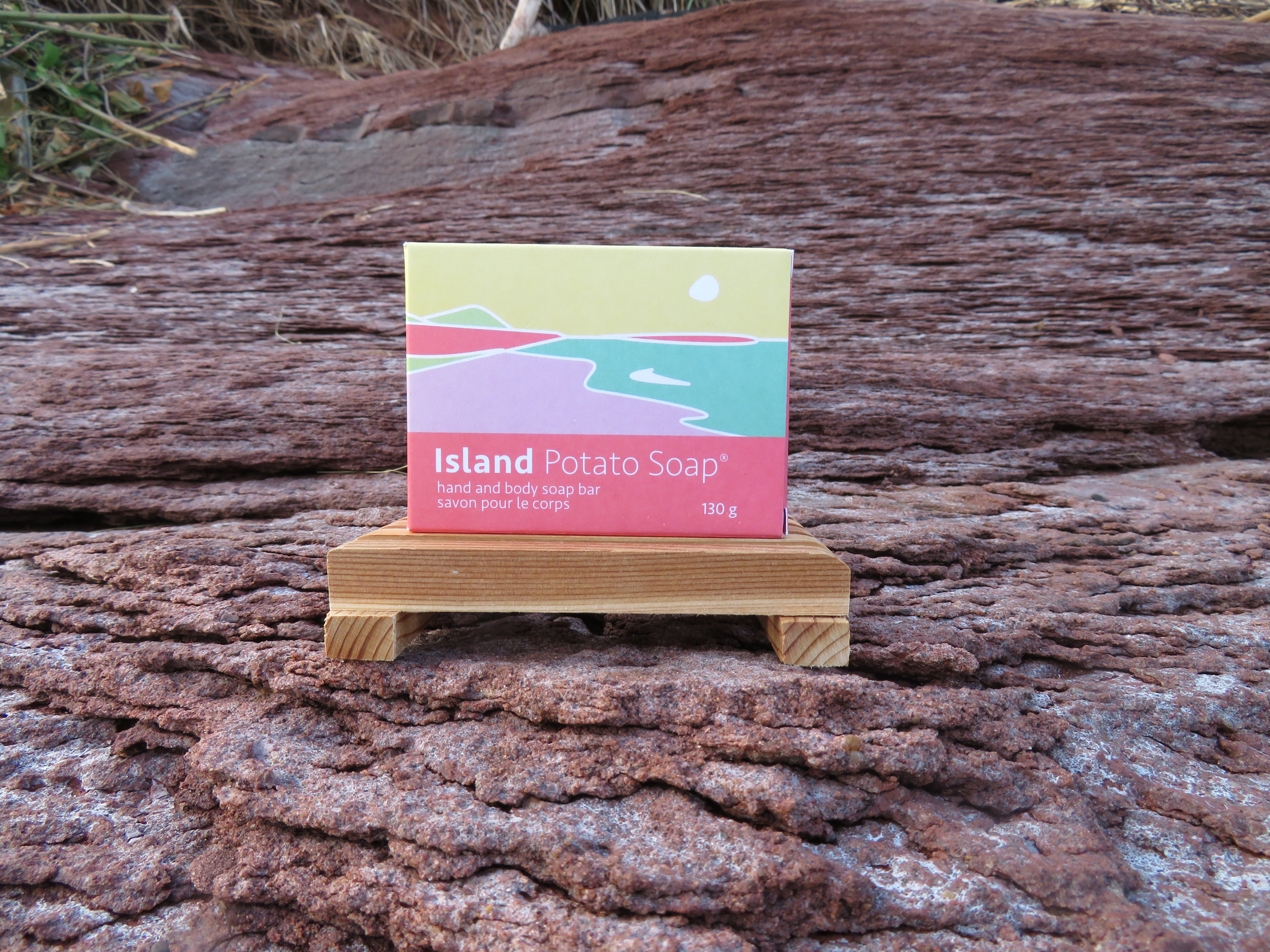 Island Potato Soap packaging on a wooden stand against a natural background