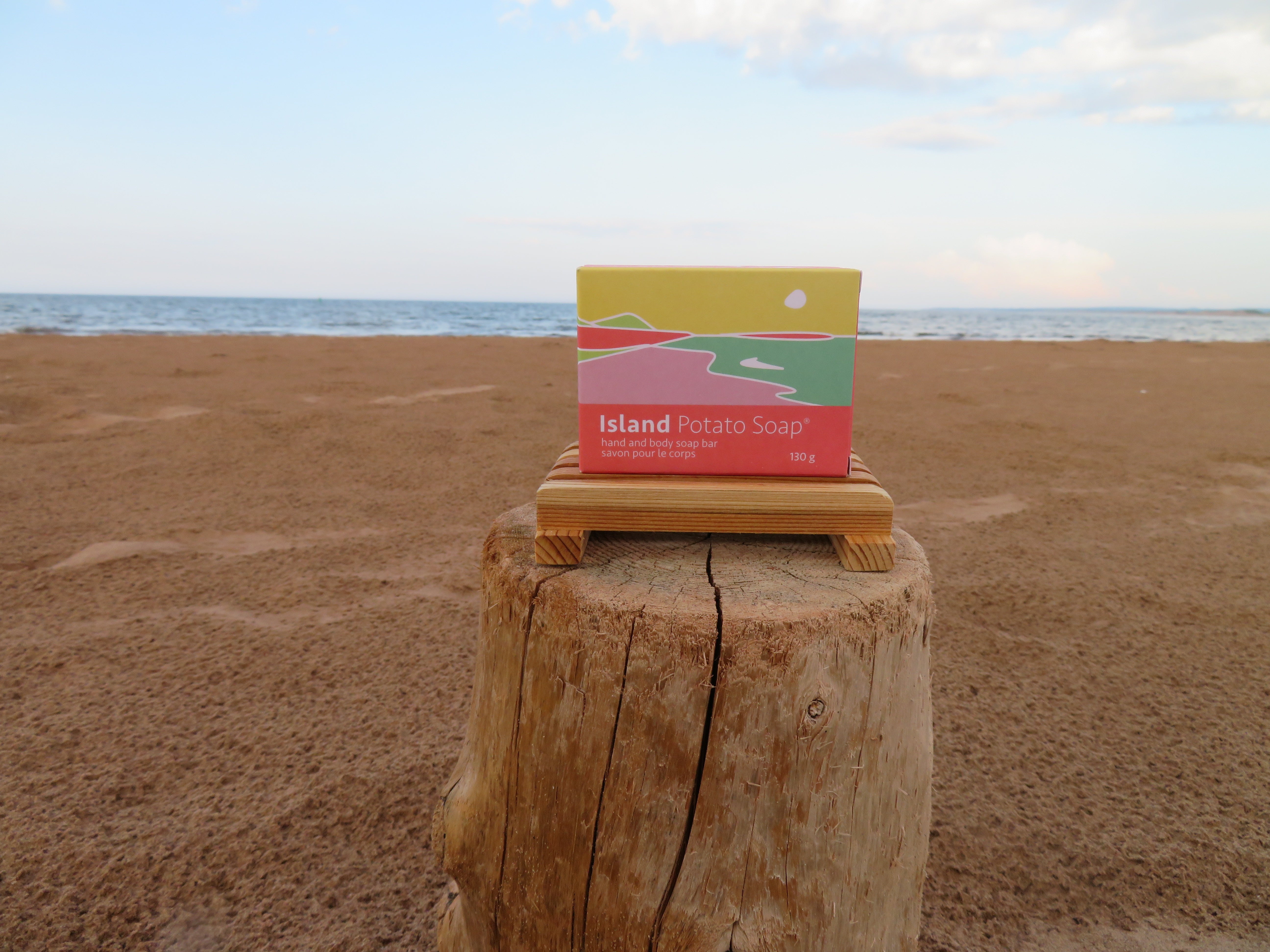 Box of Island Potato Soap on a wooden block with ocean and sky in the background
