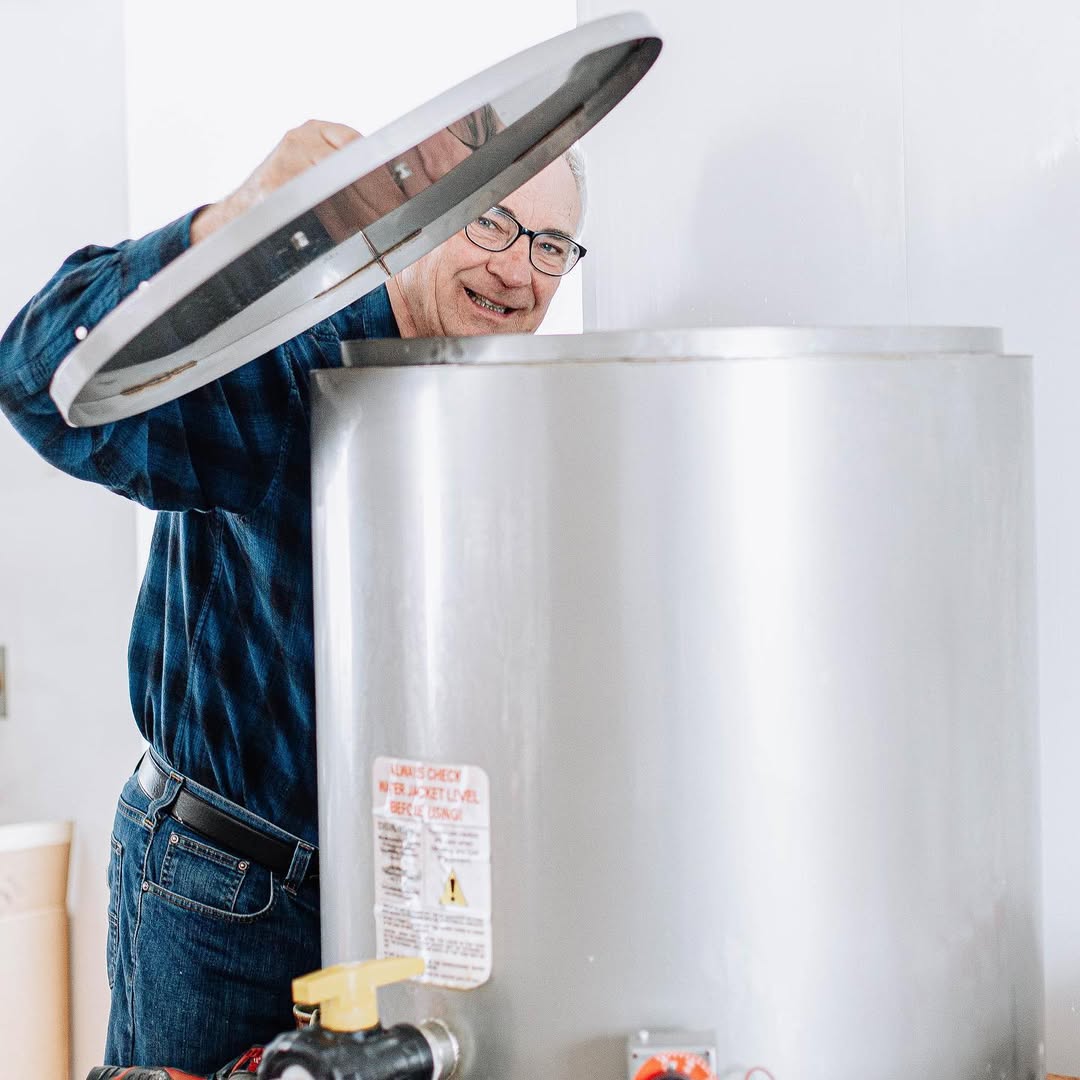 Person working on a water heater with a white background