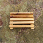 Wooden soap dish attached to a textured stone wall