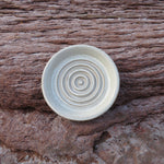 Ceramic bowl with concentric circle pattern on a wooden surface