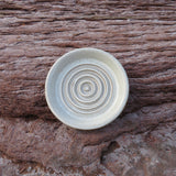Ceramic bowl with concentric circle pattern on a wooden surface