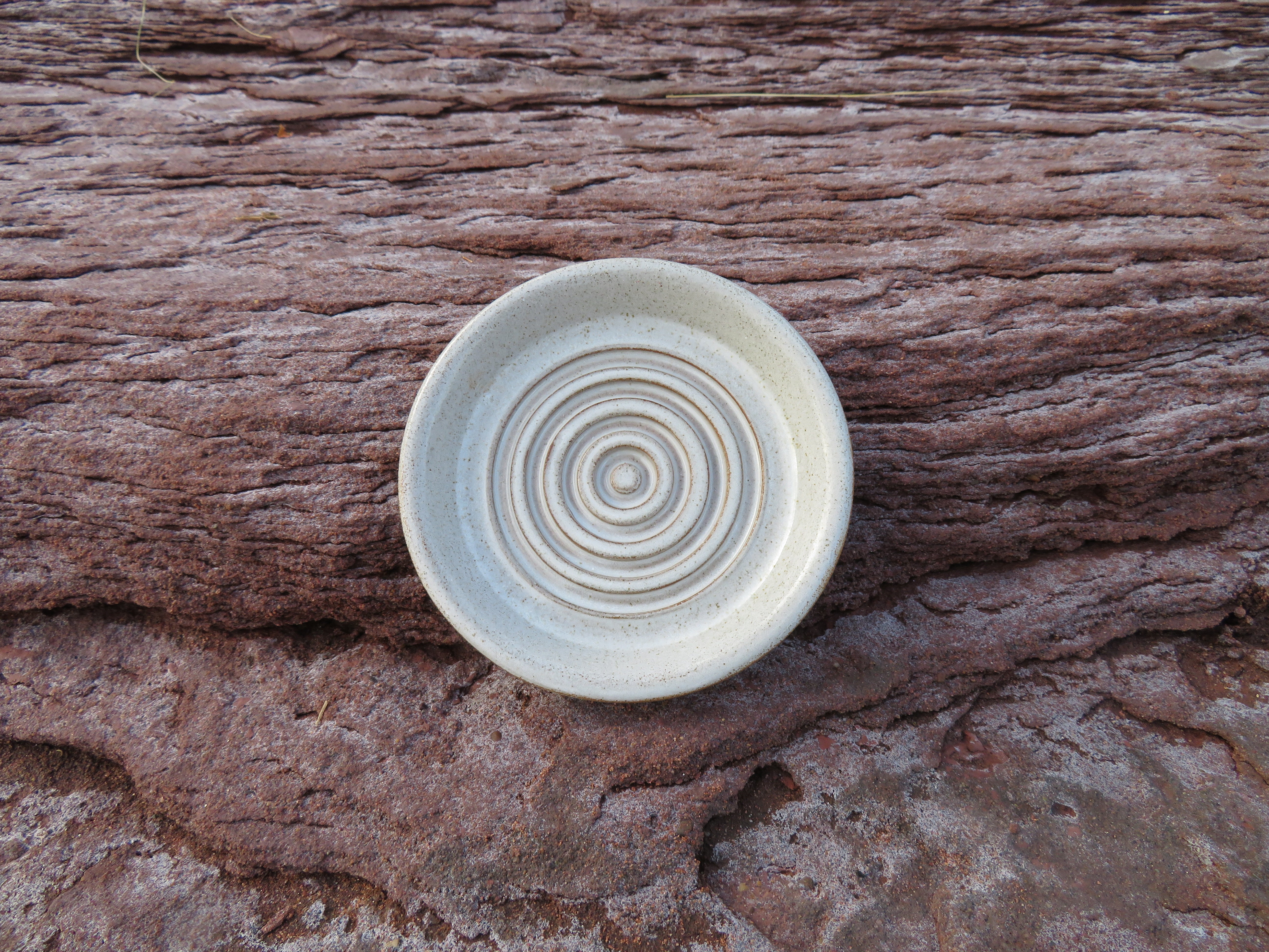 Ceramic bowl with concentric circle pattern on a wooden surface