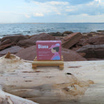 Product packaging labeled 'Diana' on a wooden log with a beach background