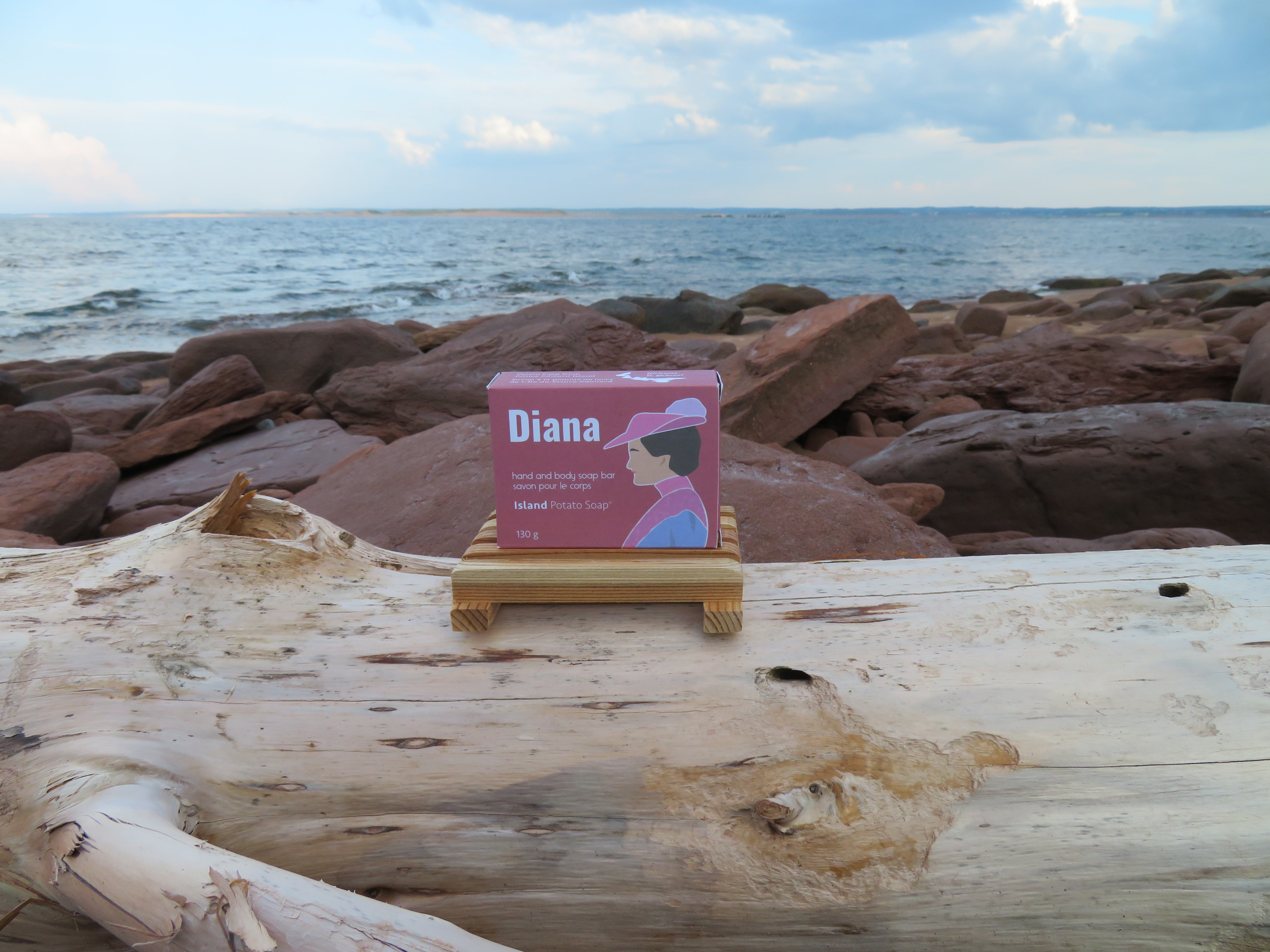 Product packaging labeled 'Diana' on a wooden log with a beach background