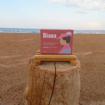 Bar of soap with 'Diana' packaging on a wooden block at the beach
