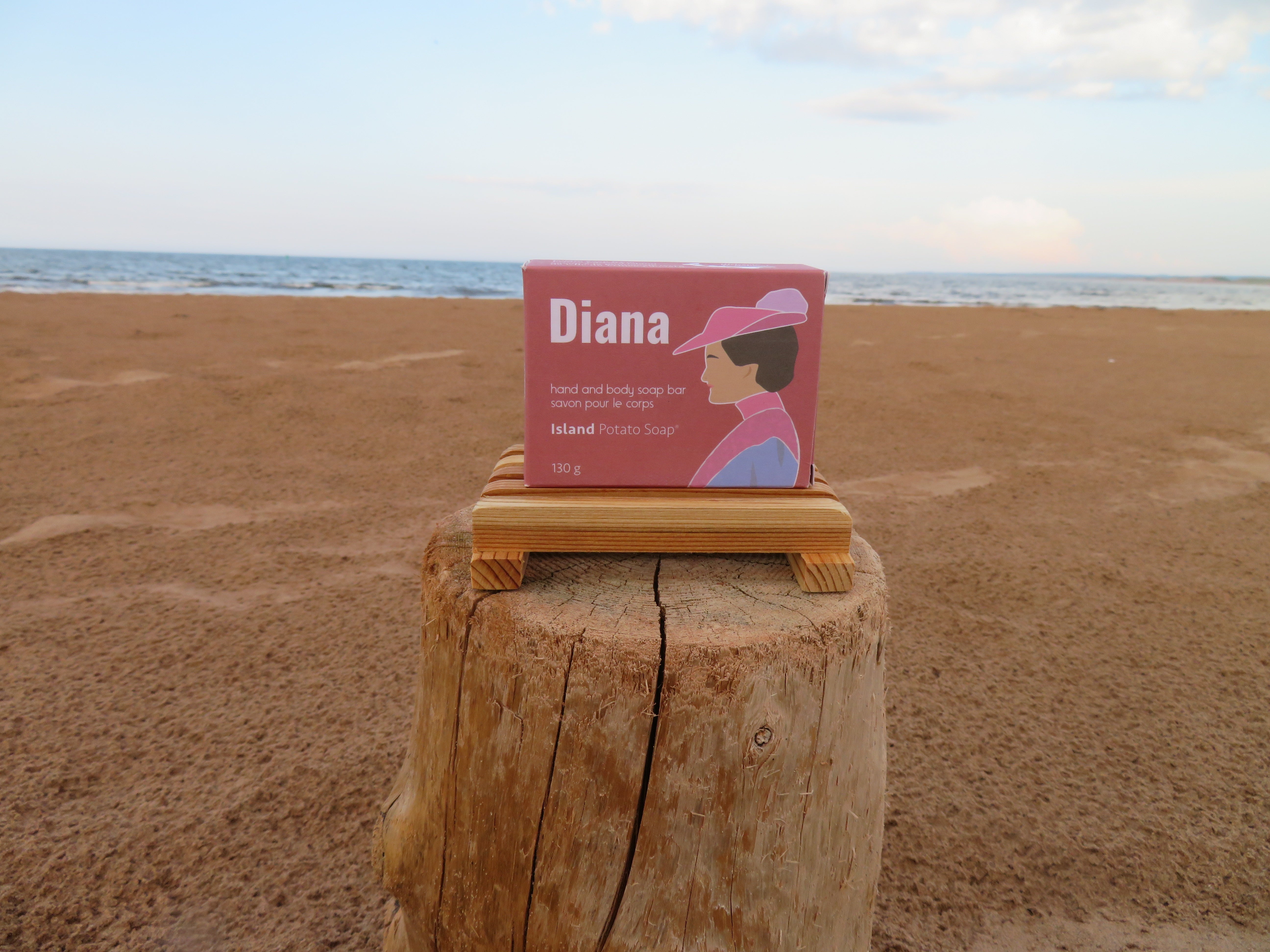 Bar of soap with 'Diana' packaging on a wooden block at the beach