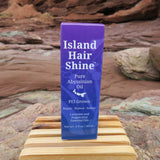 Island Hair Shine product on a wooden block with a natural rock background