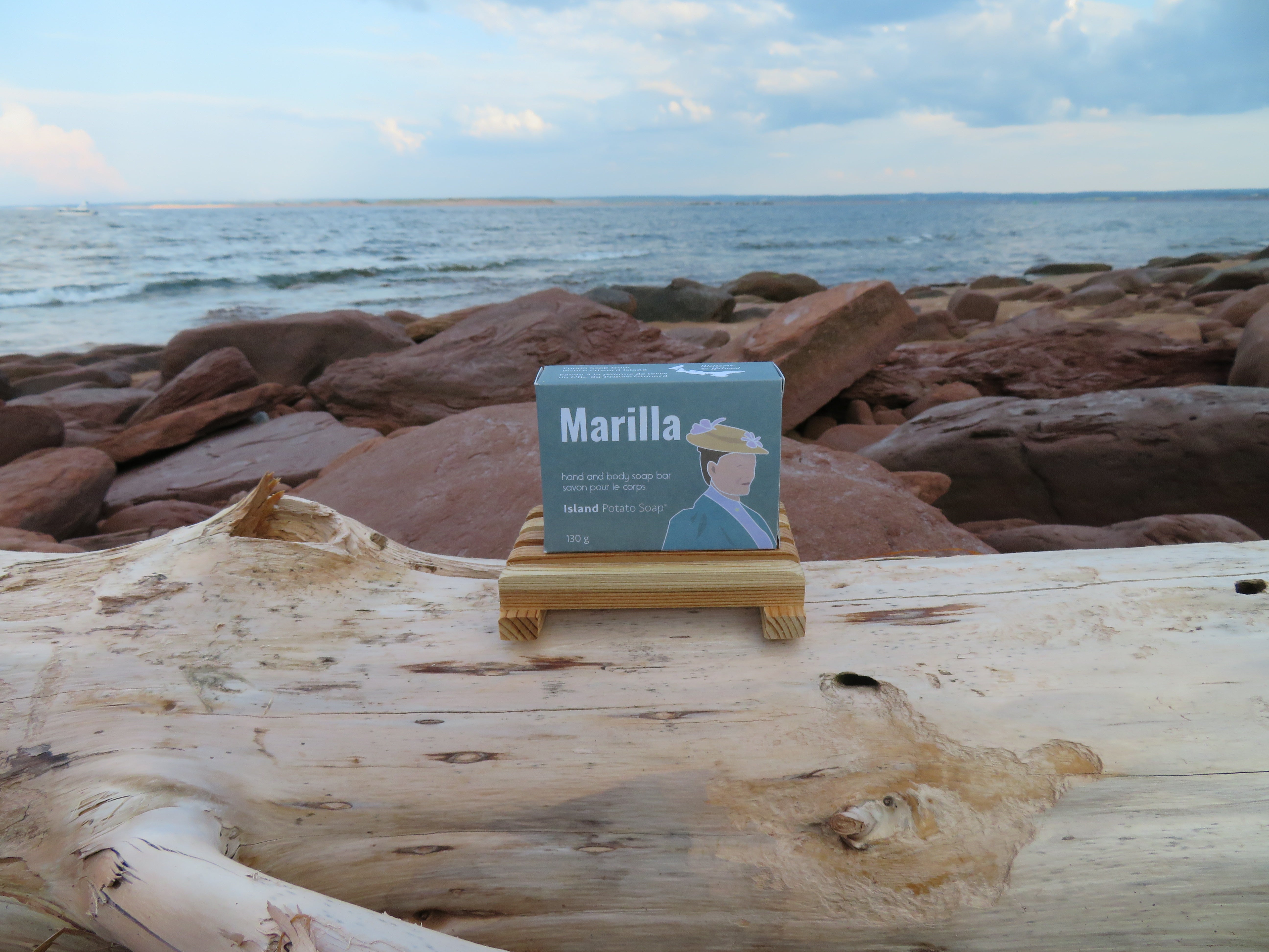 Book titled 'Marilla' on a wooden stand with a scenic ocean background