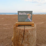 Product packaging on a wooden stump with a beach background