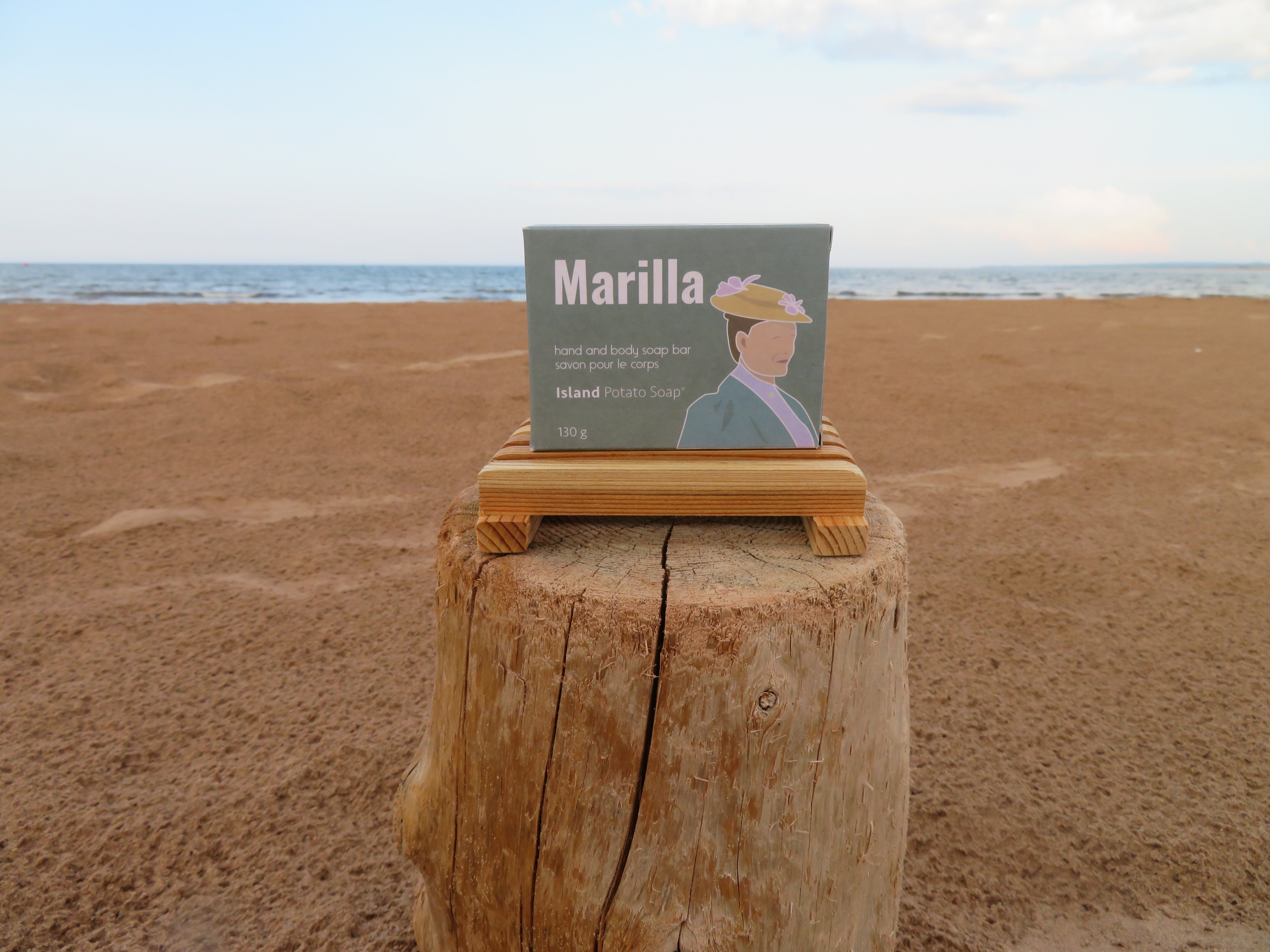 Product packaging on a wooden stump with a beach background
