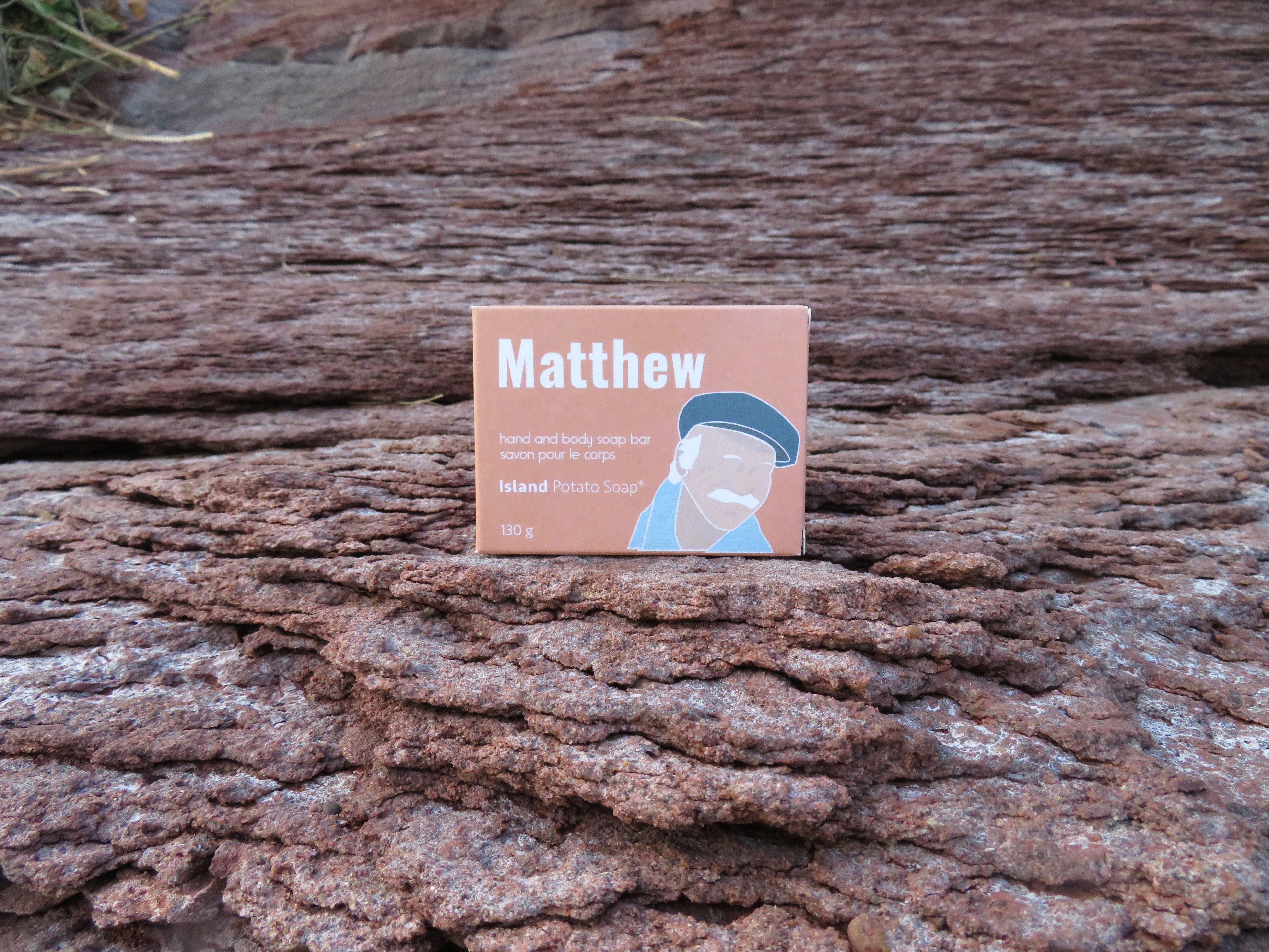 Soap packaging with a person's name on it placed on textured brown surface