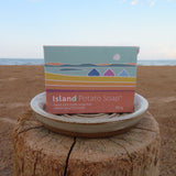 Island Potato Soap packaging on a beach with ocean view
