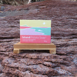 Island Potato Soap packaging on a wooden stand against a natural background