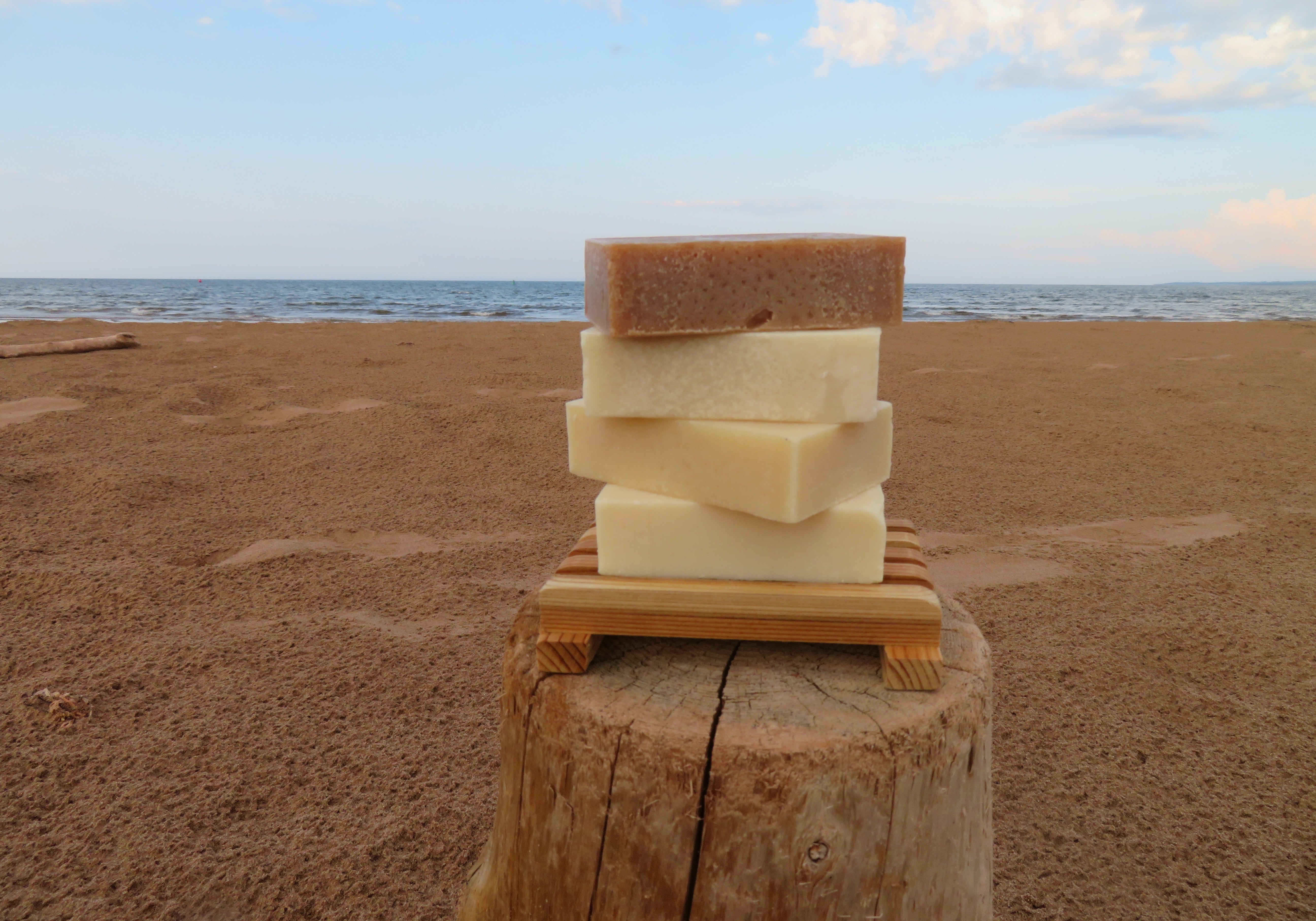 Stack of soap bars on a wooden block with a beach background
