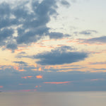 Sunset over water with clouds in the sky