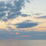 Sunset over water with clouds in the sky