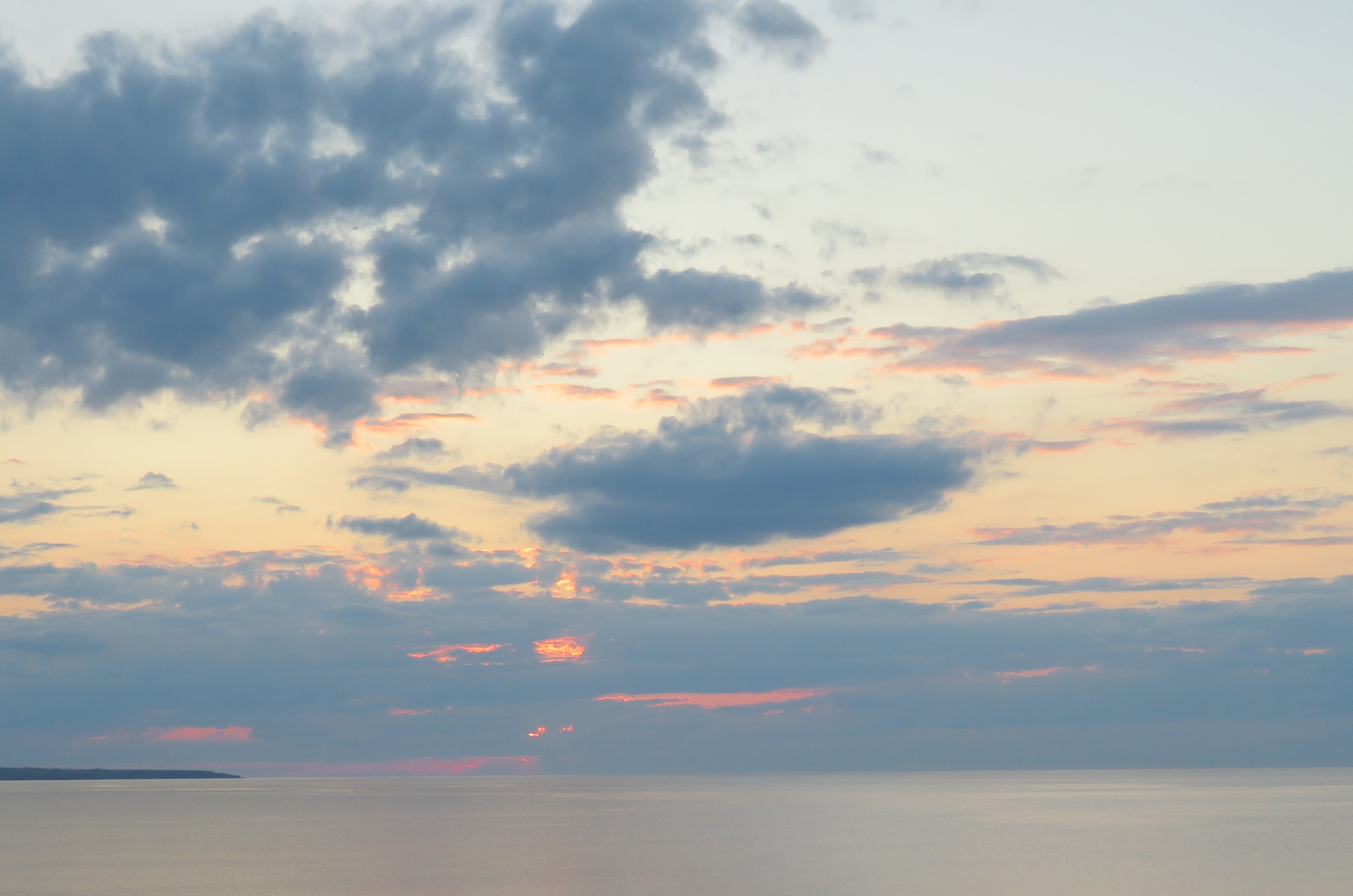 Sunset over water with clouds in the sky