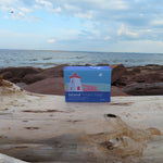 Box of Island Potato Soap on a piece of driftwood with a beach and ocean background