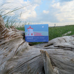 Box of Island Potato Soap on a piece of driftwood with a lighthouse in the background