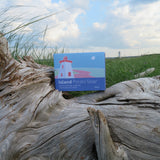 Box of Island Potato Soap on a piece of driftwood with a lighthouse in the background