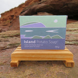 Island Potato Soap packaging on a wooden stand with a natural background