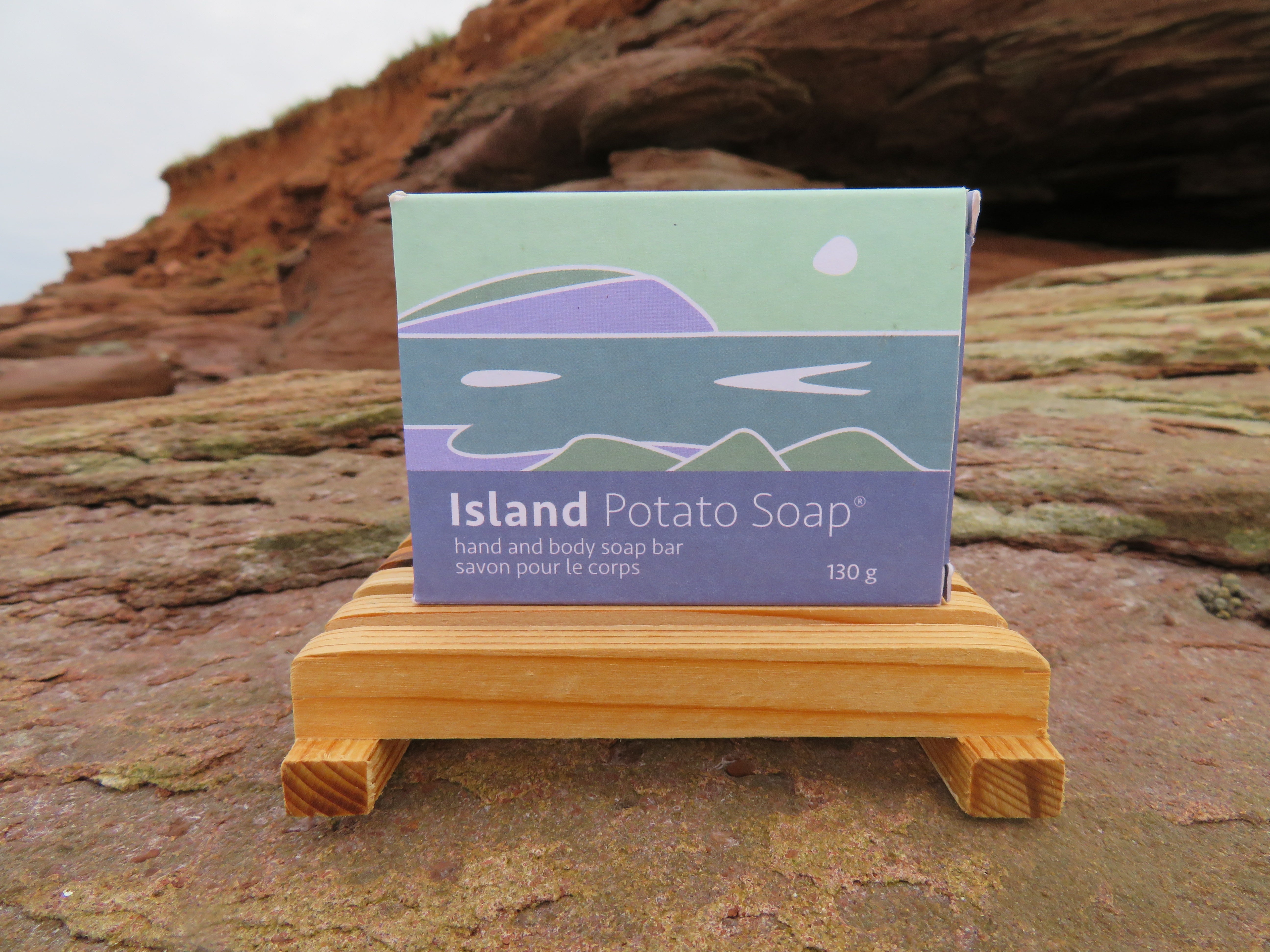 Island Potato Soap packaging on a wooden stand with a natural background