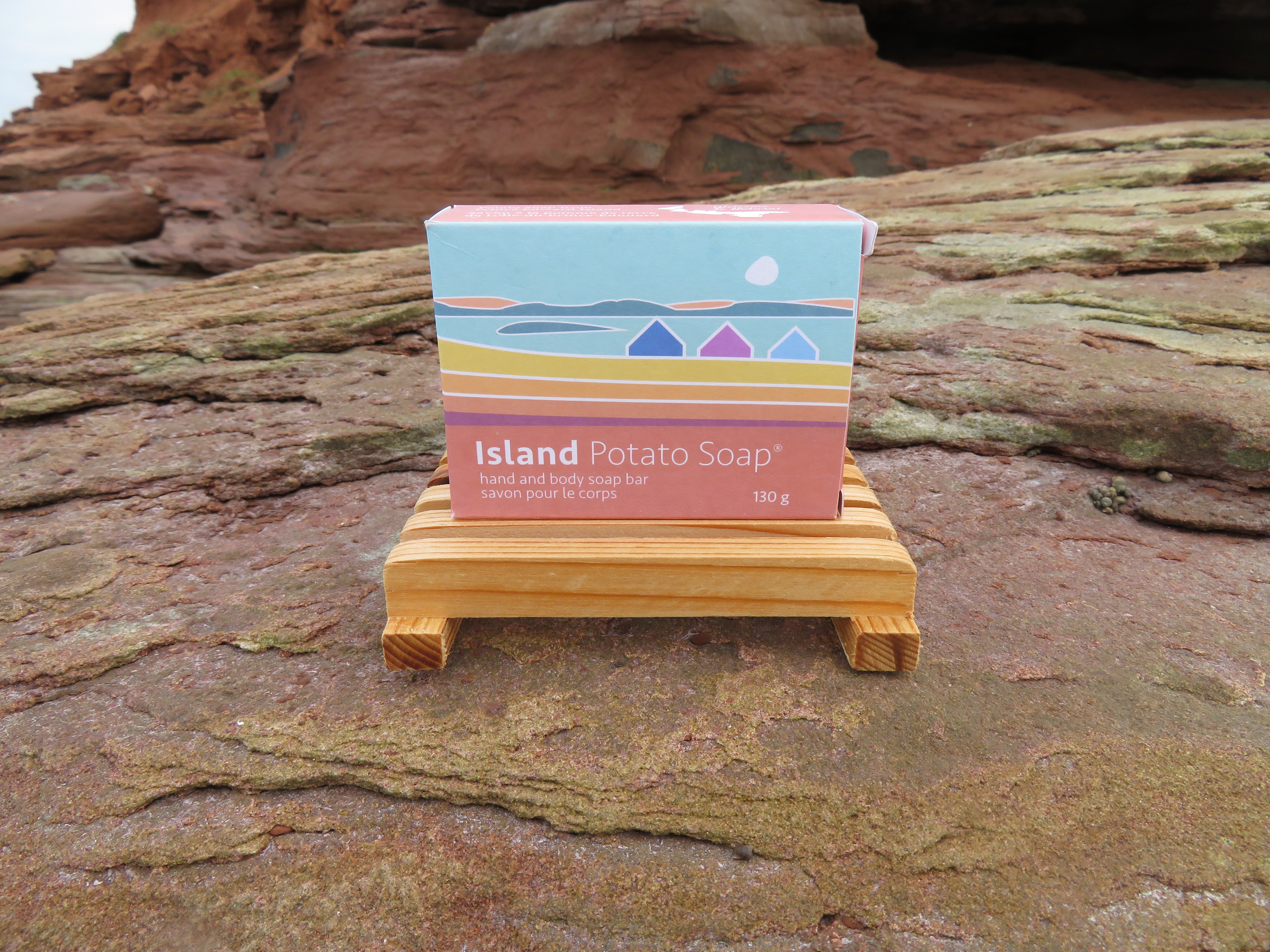 Box of Island Potato Soap on a wooden stand with a natural rock background